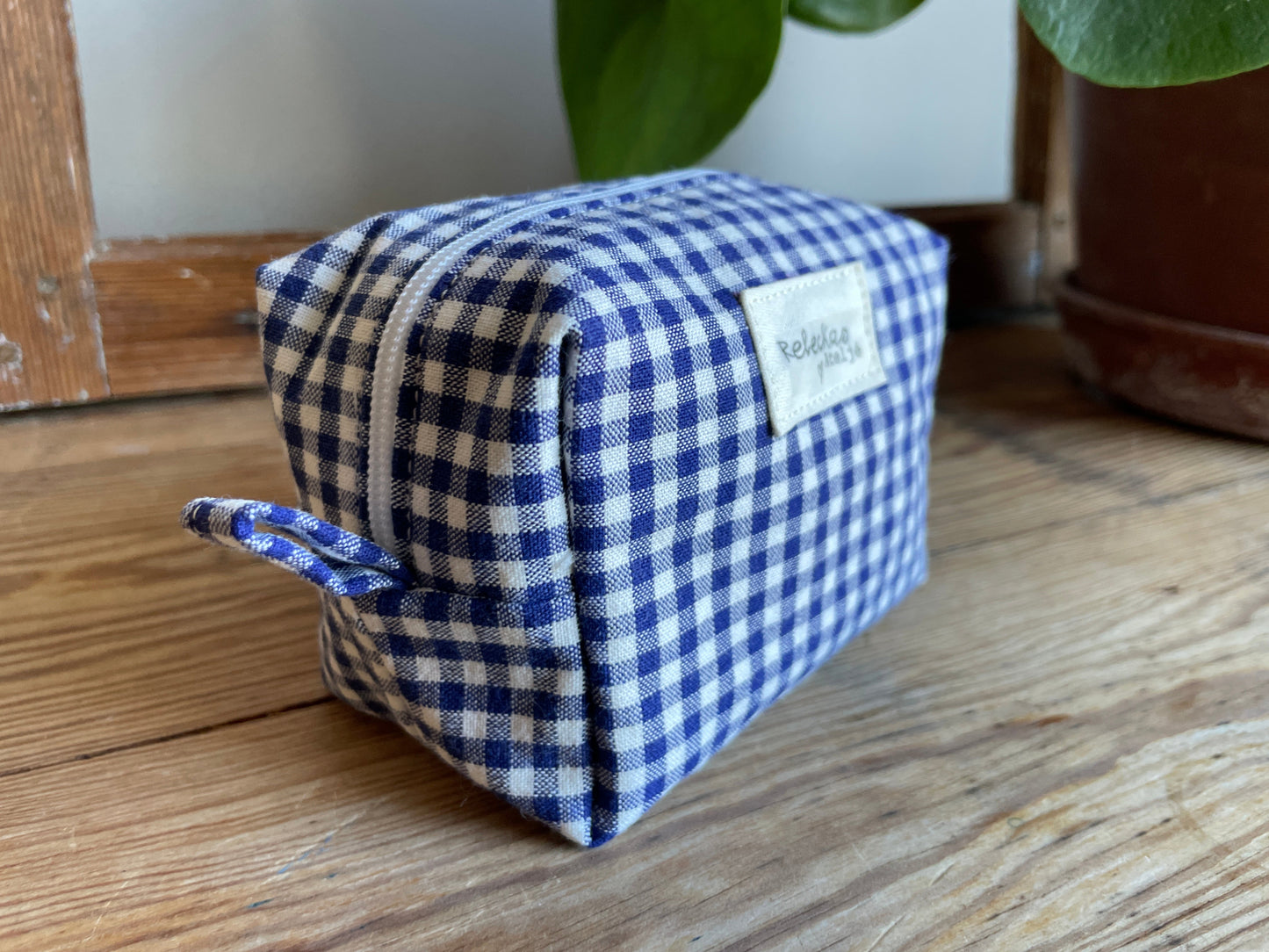 Mini boxnecessär i blåvitrutigt tyg med dragkedja.