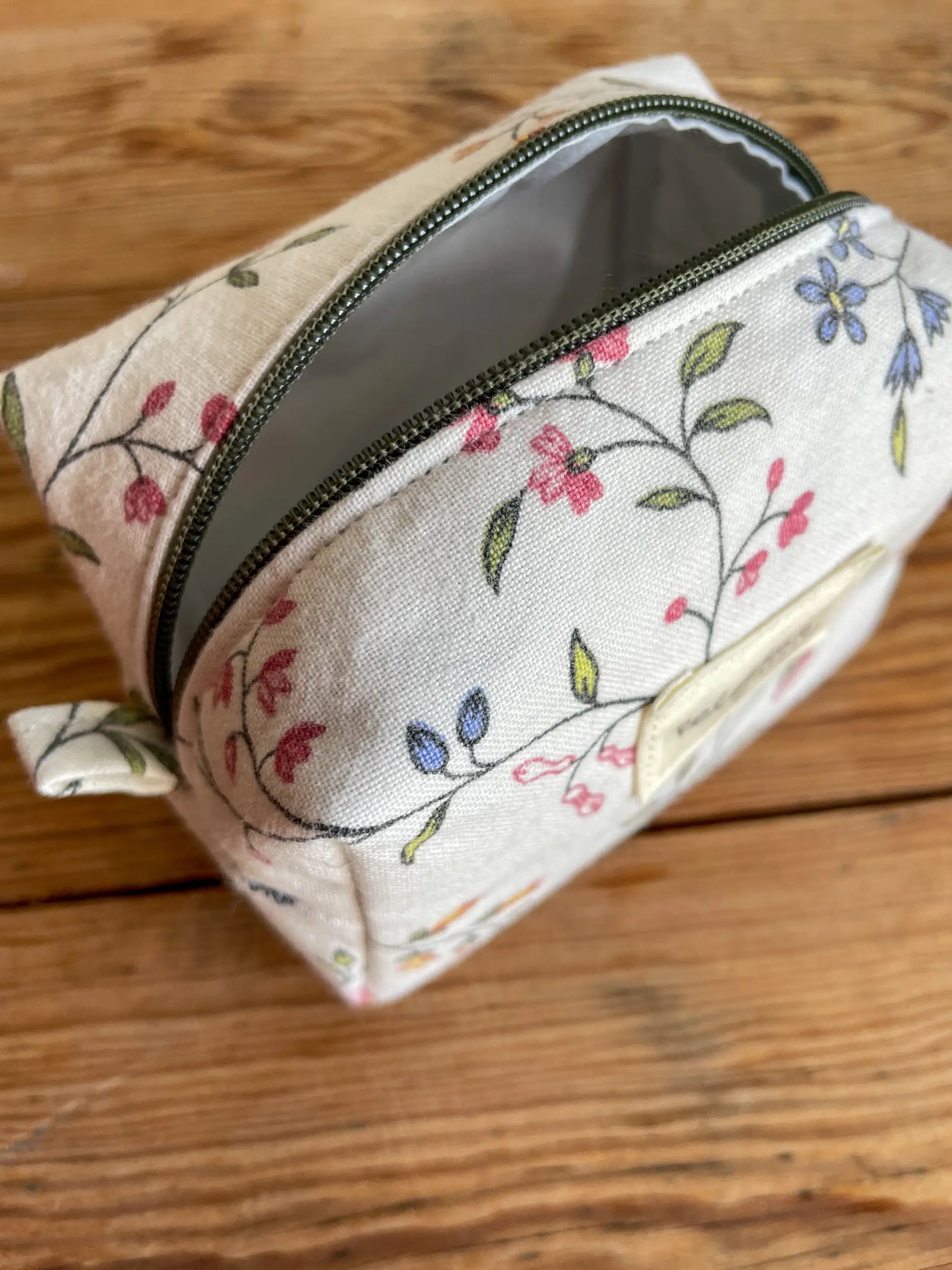 Mini Boxnecessär med blommigt tyg i vitt och grönt, flerfärgade blommor och mörkgrönt blixtlås.