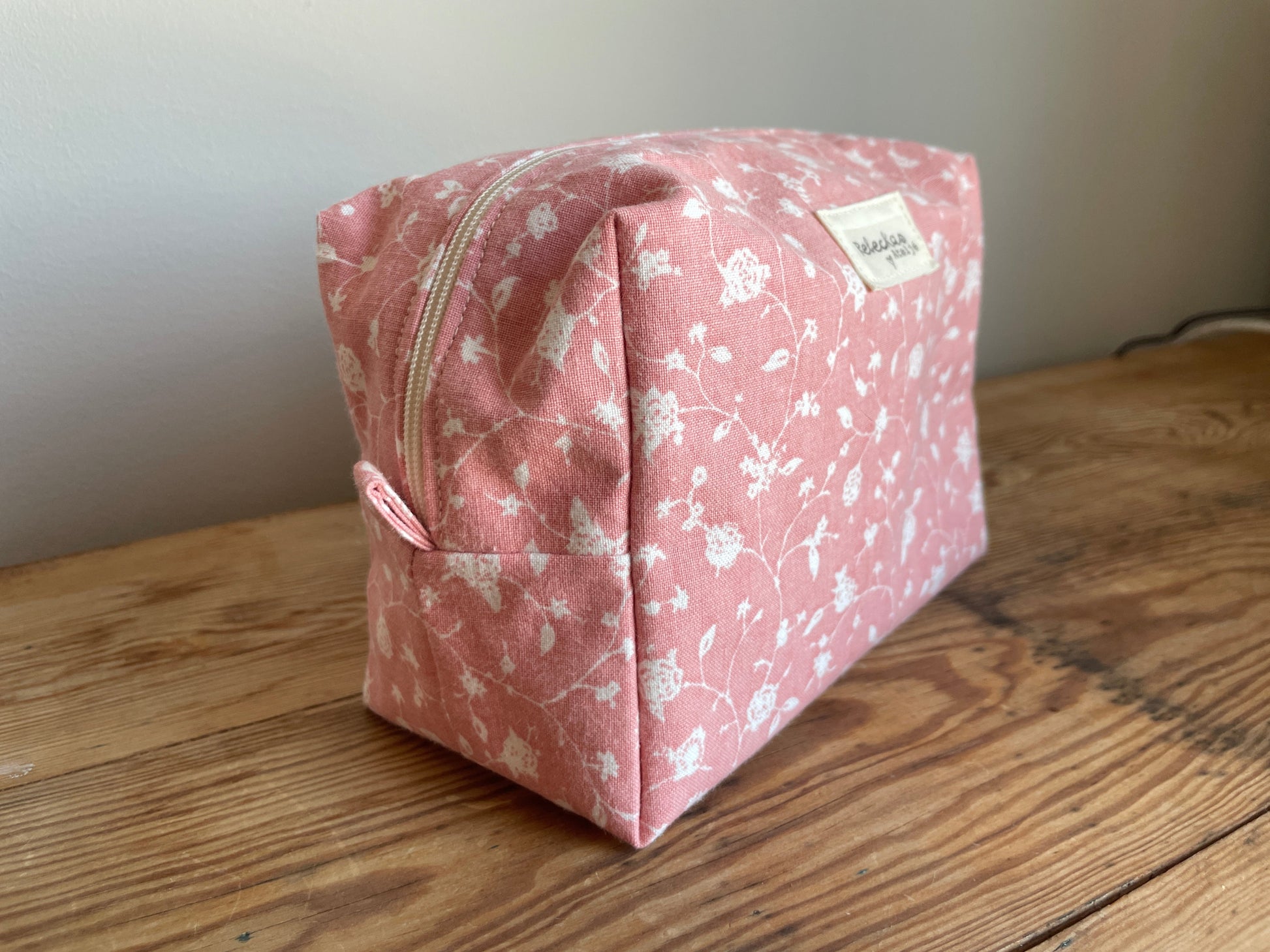 Handgjord boxnecessär i tyg med rosa bakgrund, små vita blommor och dragkedja
