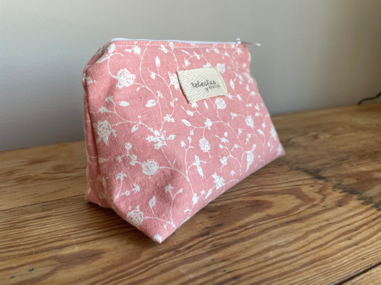 Klassisk necessär i tyg med rosa mönster och vita blommor, med dragkedja upptill