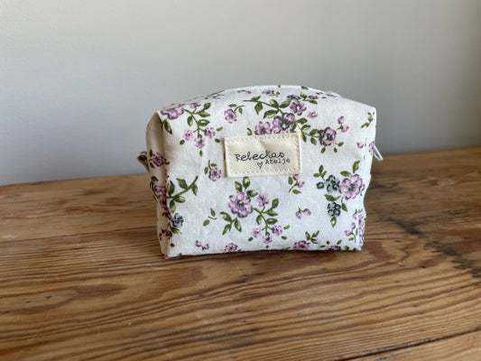 Handgjord mini boxnecessär i tyg med vit bakgrund, små lila blommor och vit dragkedja.