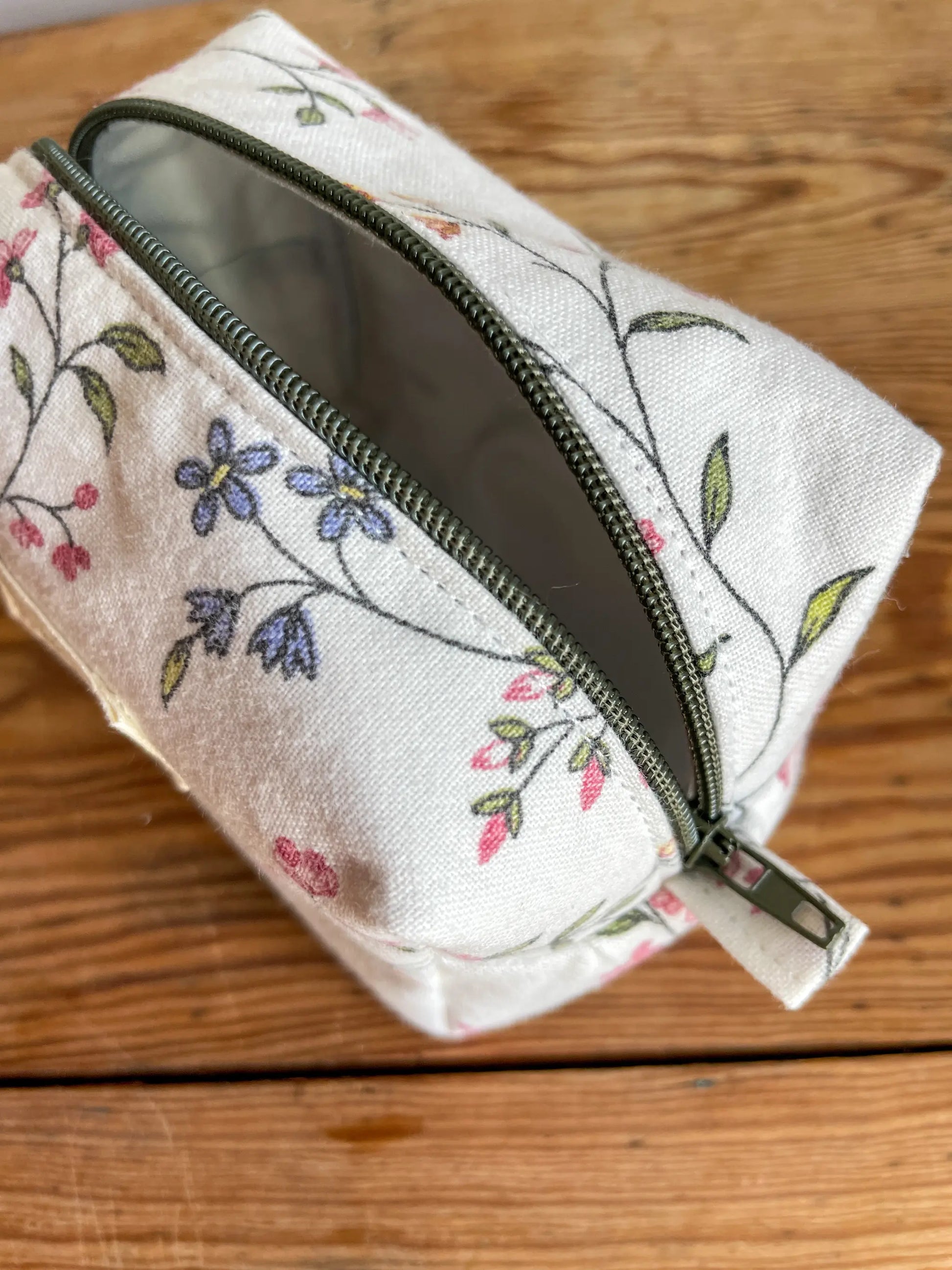 Mini Boxnecessär med blommigt tyg i vitt och grönt, flerfärgade blommor och mörkgrönt blixtlås.