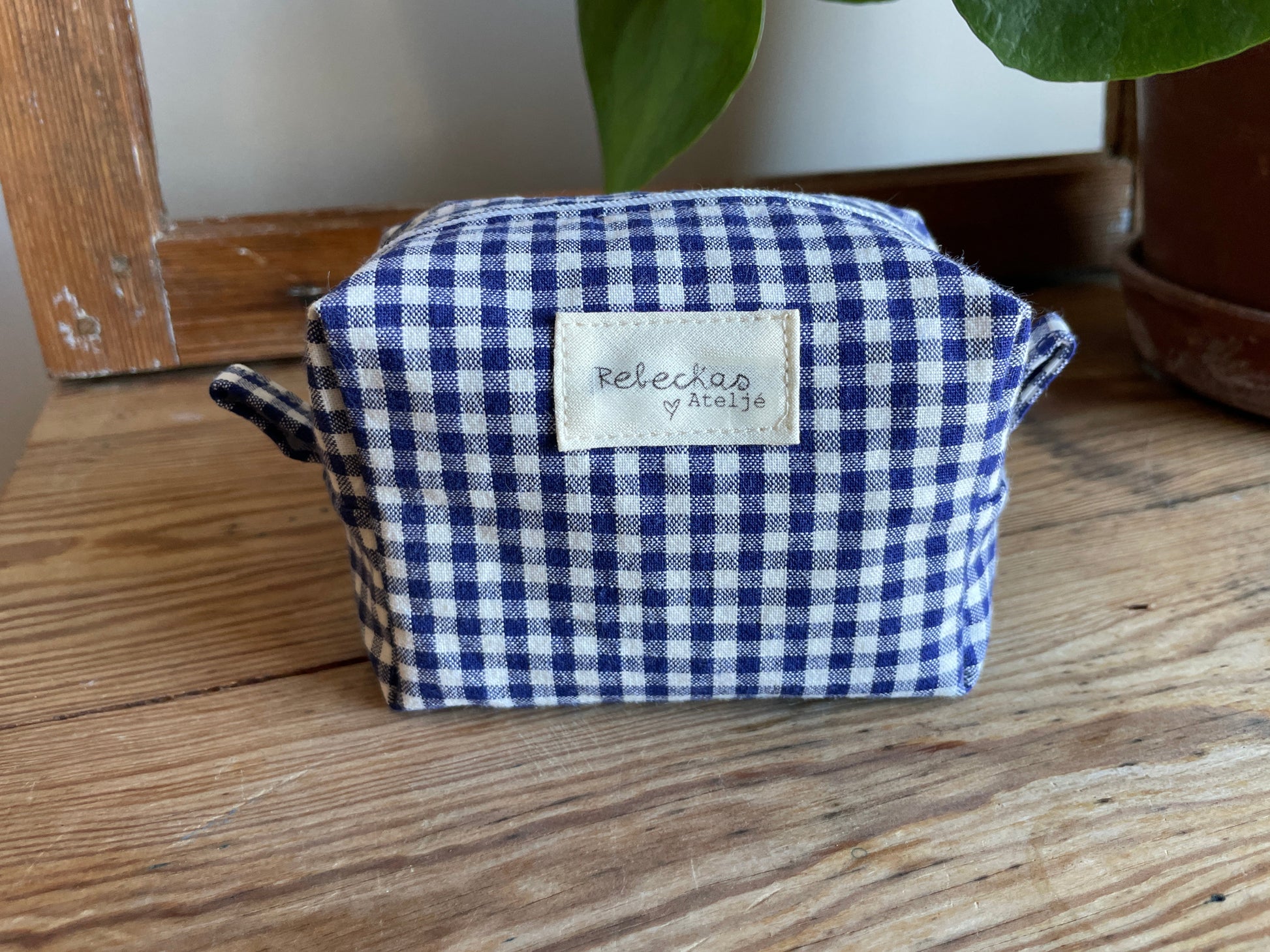 Mini boxnecessär i blåvitrutigt tyg med dragkedja.