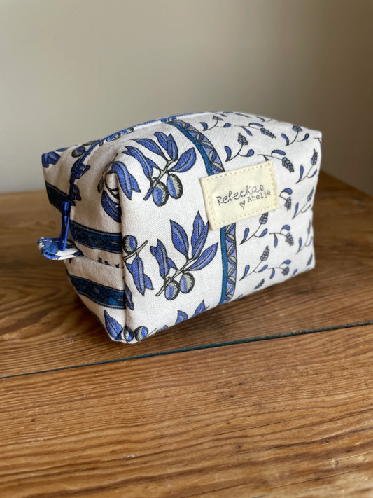 Mini boxnecessär i vitt tyg med blått blommönster och olivkvistar, handsydd med blå dragkedja.
