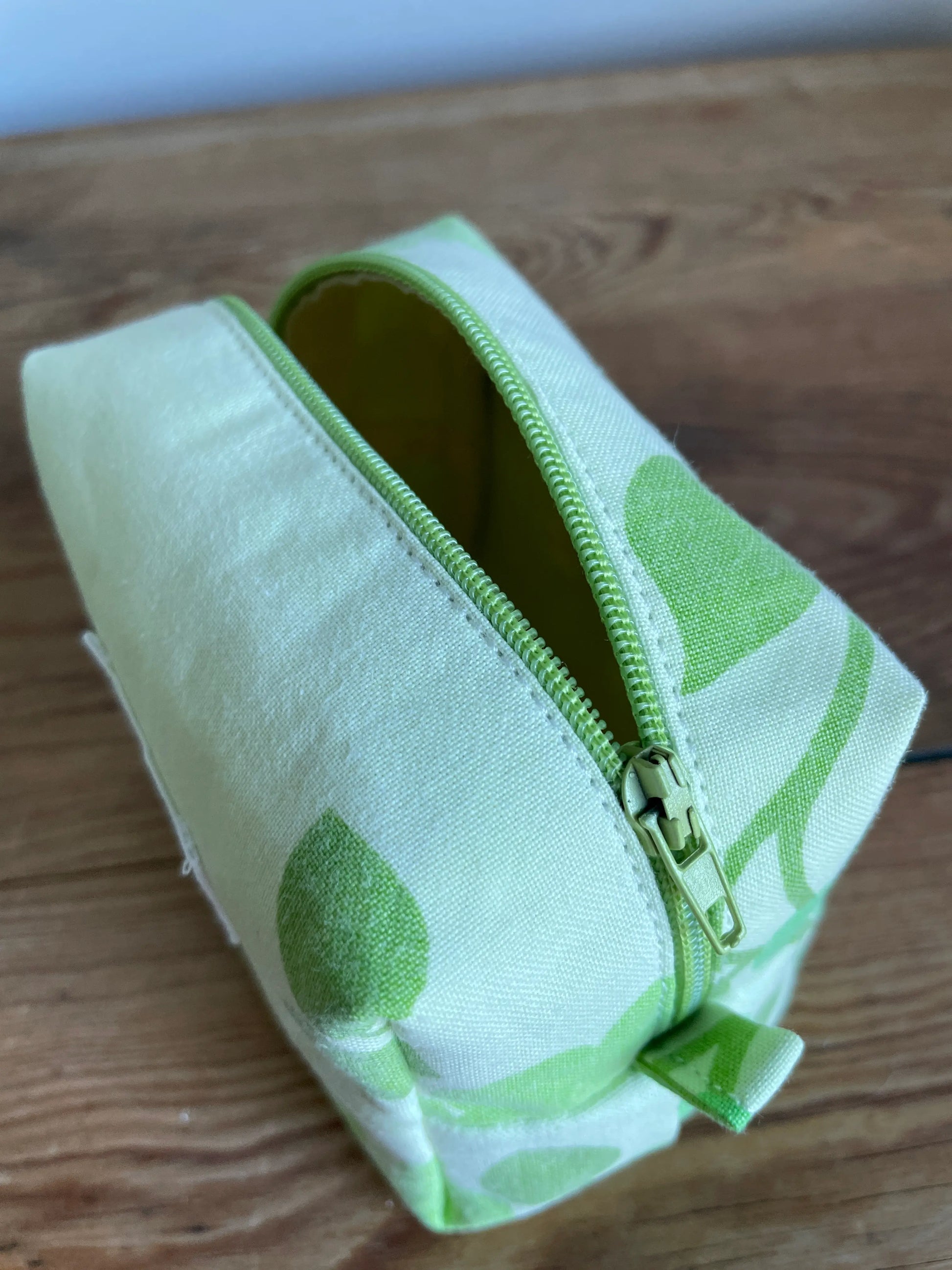 Mini boxnecessär i grönt bomullstyg med retroinspirerat blommönster i flera nyanser av grönt. Handsydd necessär med rymlig boxform som passar för sticktillbehör, virknålar, smink, toalettartiklar och annan praktisk förvaring. Det gröna mönstret ger en frisk och nostalgisk känsla inspirerad av svensk sommar och natur.