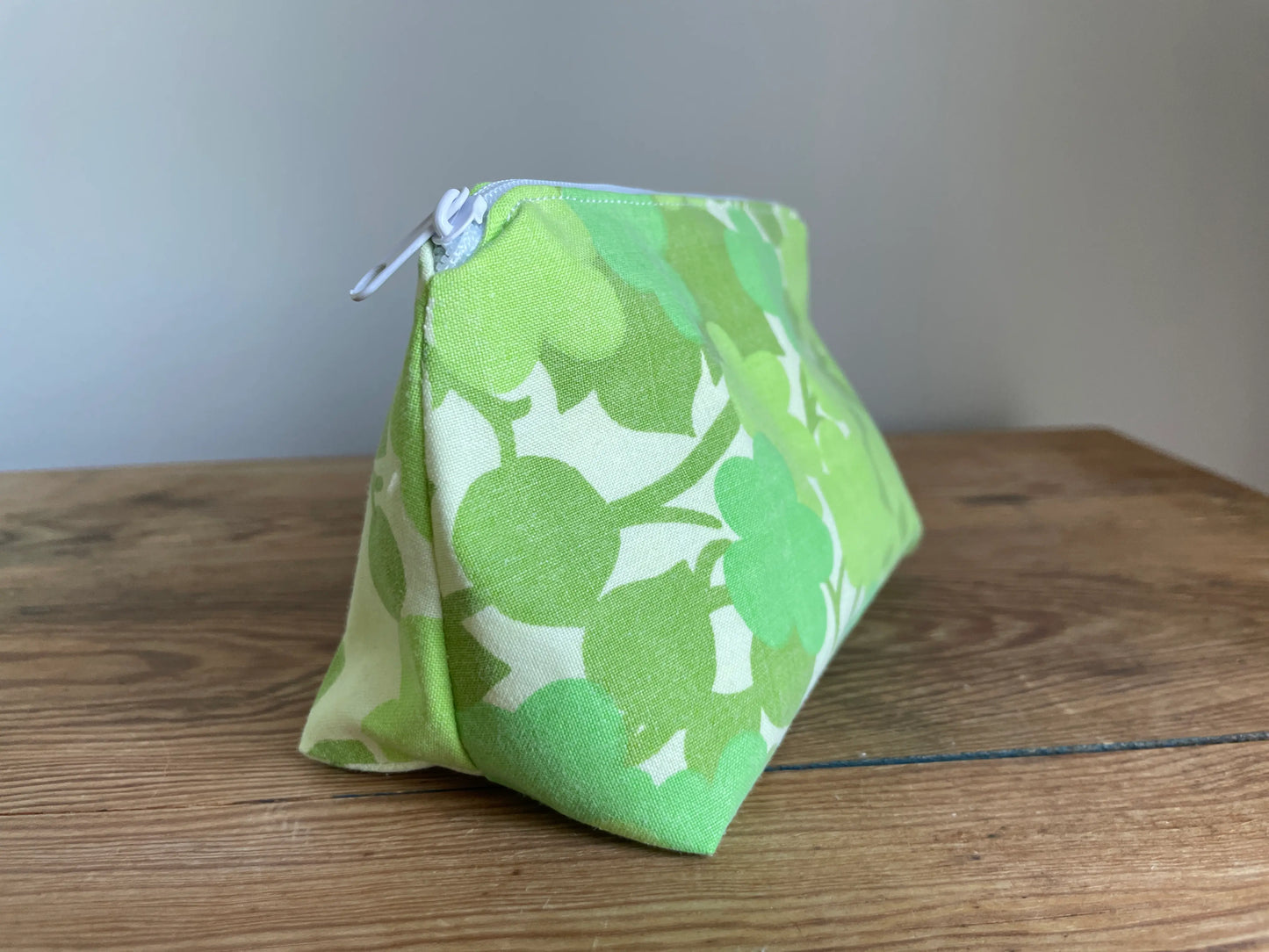 Necessär i klassisk modell i grönt bomullstyg med retroinspirerat blommönster i flera nyanser av grönt. Handsydd necessär med rymlig form som passar för sticktillbehör, virknålar, smink, toalettartiklar och annan praktisk förvaring. Det gröna mönstret ger en frisk och nostalgisk känsla inspirerad av svensk sommar och natur.