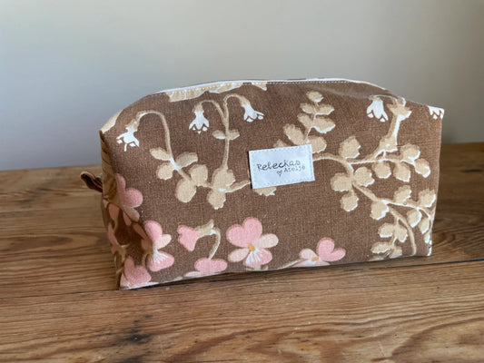 Boxnecessär i brun bomull med romantiskt blommönster i rosa, beige, creme och honungsgula toner. Handsydd necessär med rymlig boxform för smink, toalettartiklar, sticktillbehör och annan praktisk förvaring. Det vintageinspirerade blommönstret ger en varm, nostalgisk känsla med lantlig charm.