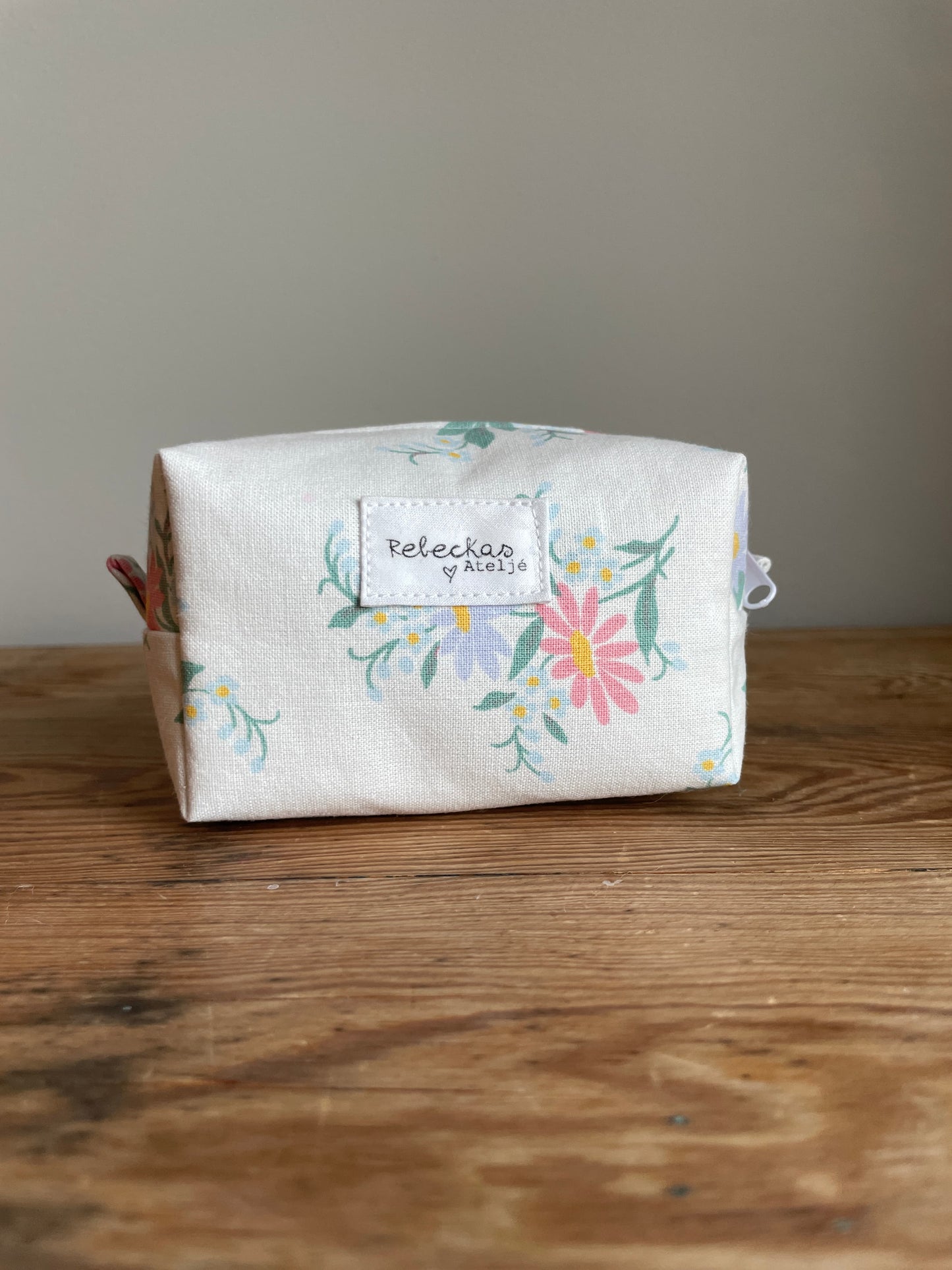 Handsydd mini necessär i boxform som passar för sticktillbehör, smink, och annan praktisk förvaring. Blommigt tyg vit dragkedja